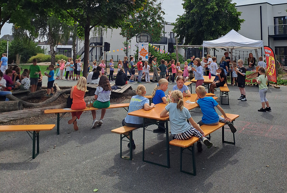Kinder sitzen, stehen und spielen auf dem Schulhof
